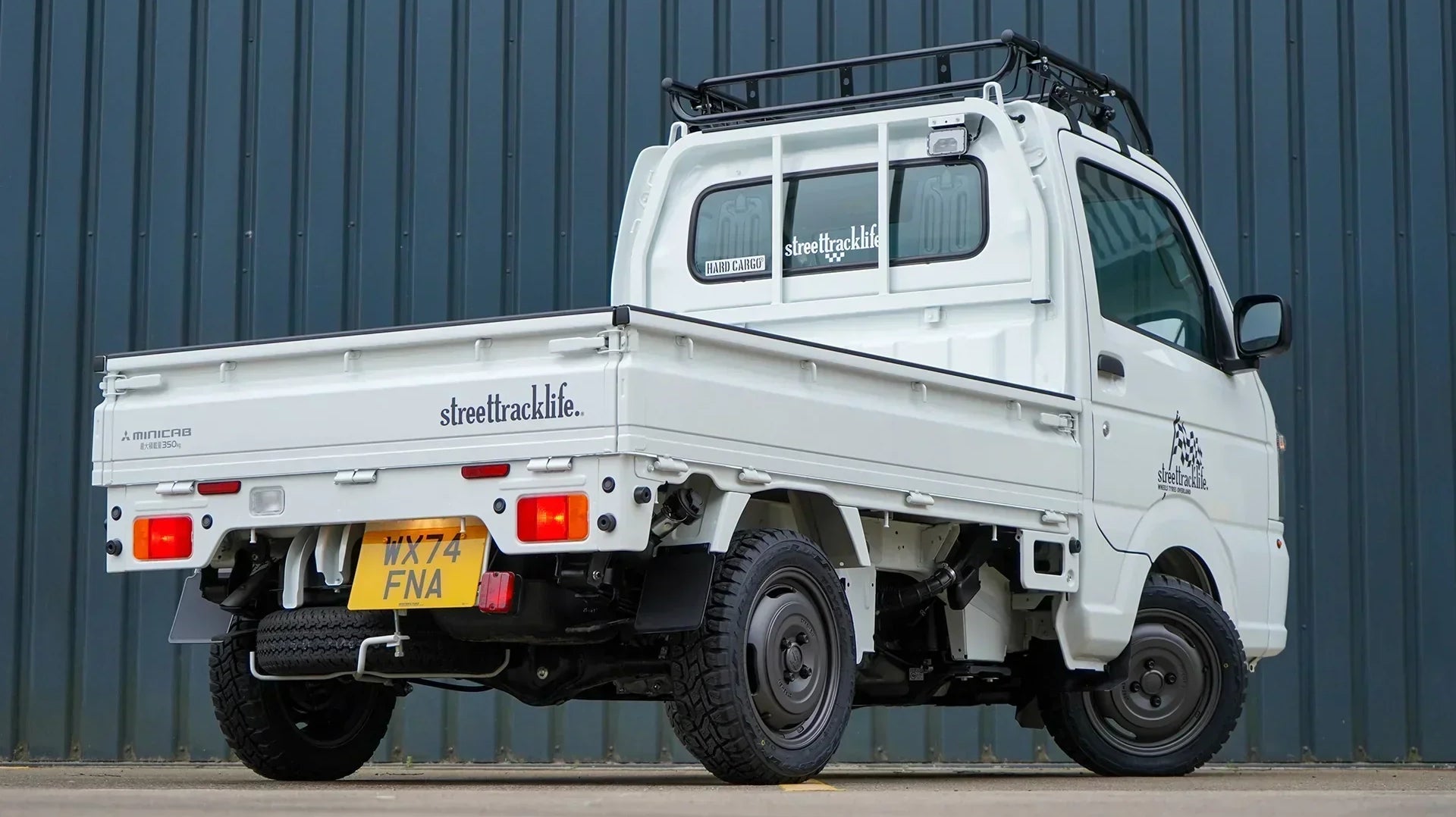 Mitsubishi minicab kei truck with xtreme-J 14 inch wheels and a hard cargo roof basket