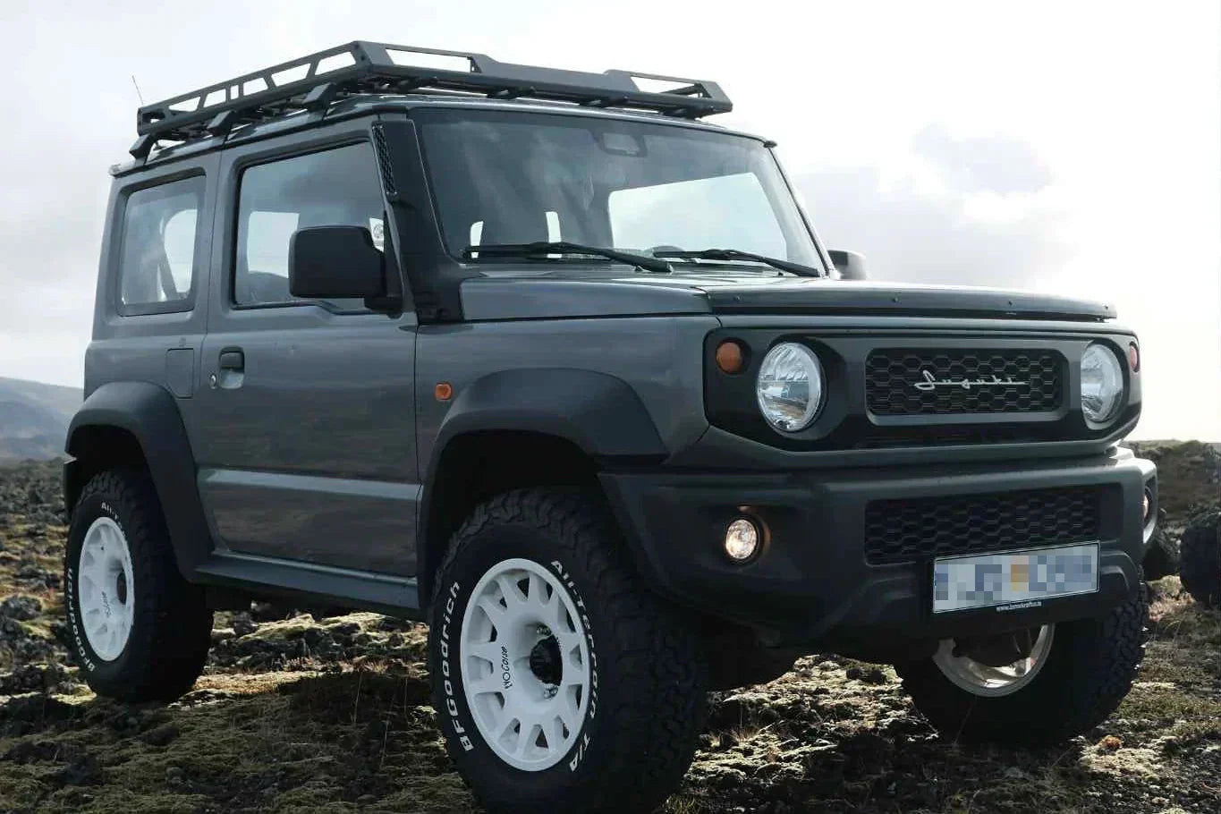 Suzuki Jimny (2018+) with 16" EVO Corse DakarZero wheels in white mounted on BF Goodrich KO2 tyres and various accessories such as retro grille and vintage emblem.