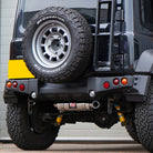 Photo of a Suzuki Jimny with a painted APIO Tactical Rear Bumper for Suzuki Jimny JB74 (2018+) fitted with a Jimy exhaust upgrade. Jimny Body kit modification. 